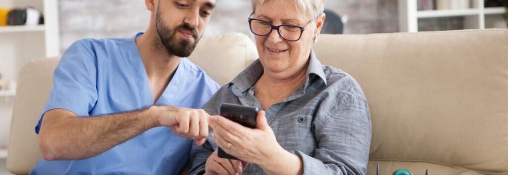 Infirmière libérale en tournée au domicile d'un patient, téléphone géré par télésecrétariat