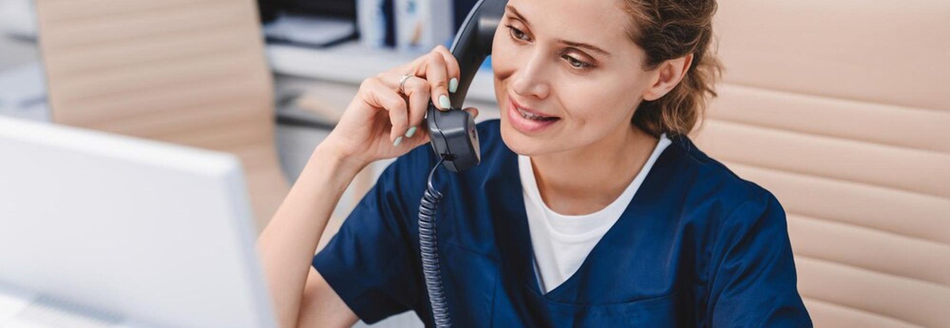 Assistante dentaire souriante répondant au téléphone dans un cabinet moderne