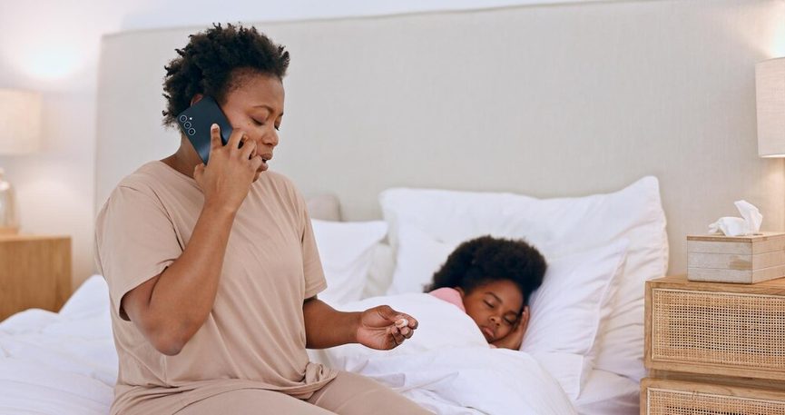 Mère tenant un bébé au téléphone en parlant à son médecin