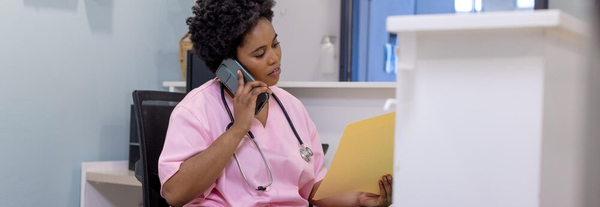 Sage-femme souriante au téléphone dans un cabinet lumineux